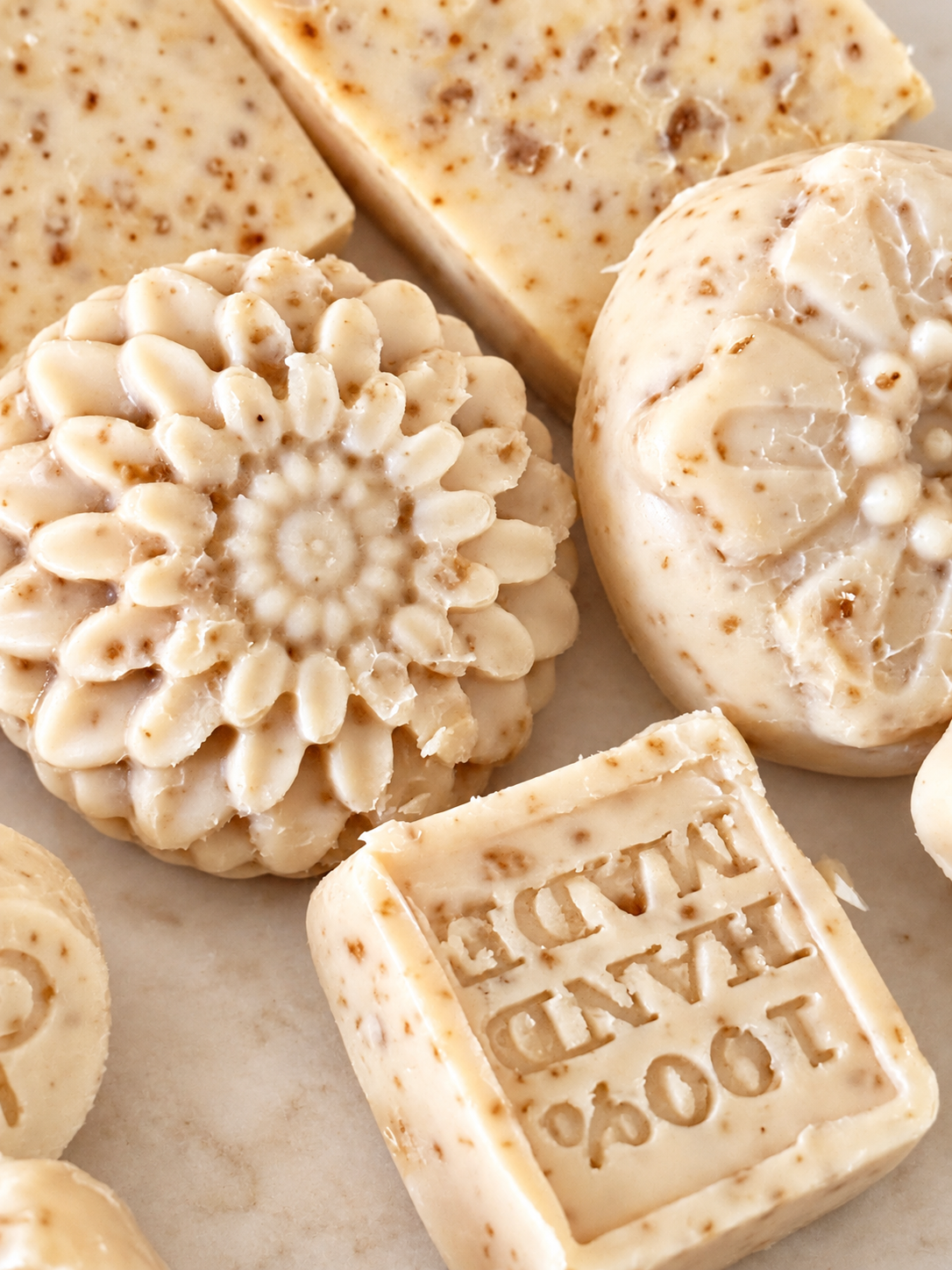 Close-up of floral and stamped handcrafted soap bars on a rack