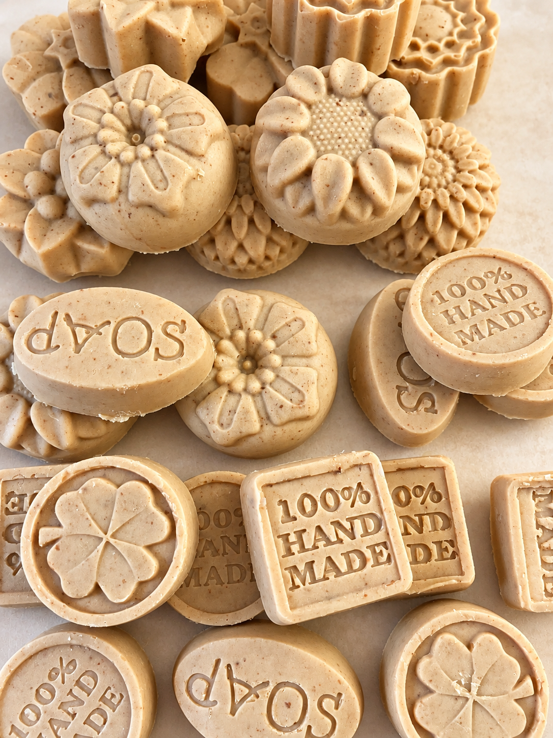 Handcrafted soaps in flower, round and square shapes on a rack